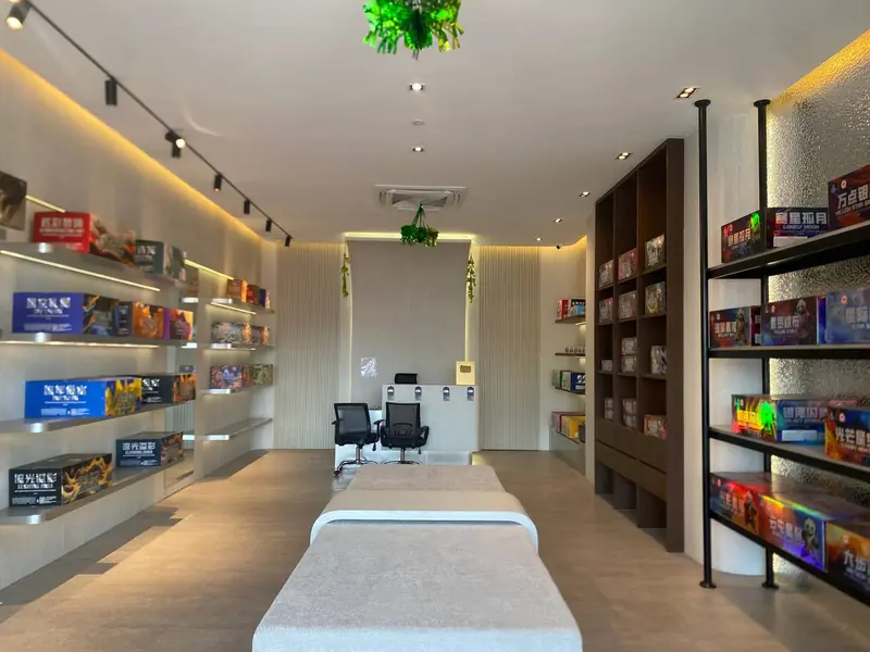 The Bangi showroom down its full length: lit shelves of printed cartons on both sides, a bench in the middle and working desks at the far end.