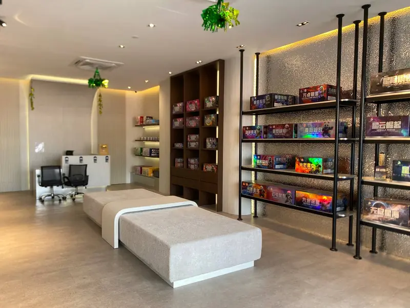 The Bangi showroom interior: printed fireworks cartons on black shelving down both walls, a bench in the middle and desks at the far end.