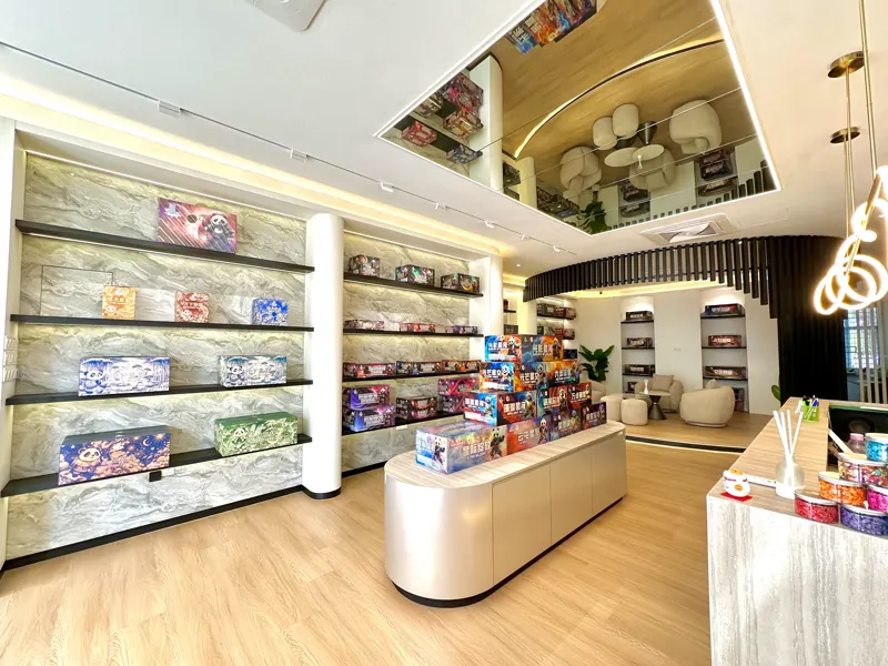 The headquarters showroom floor: lit black shelving down both walls, a central display of boxed fireworks and the service counter beyond.